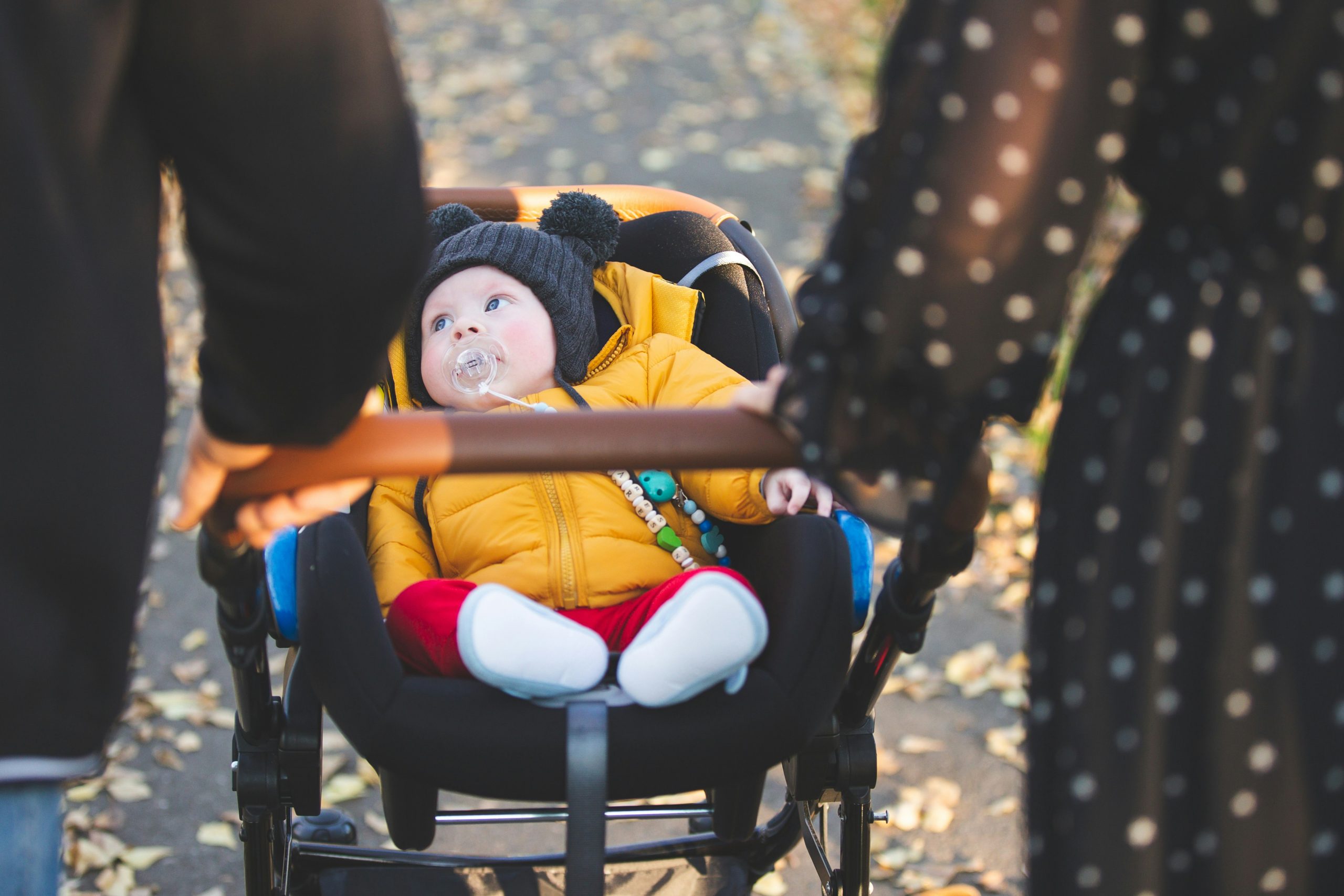 Parent pushing stroller during everyday city routine
